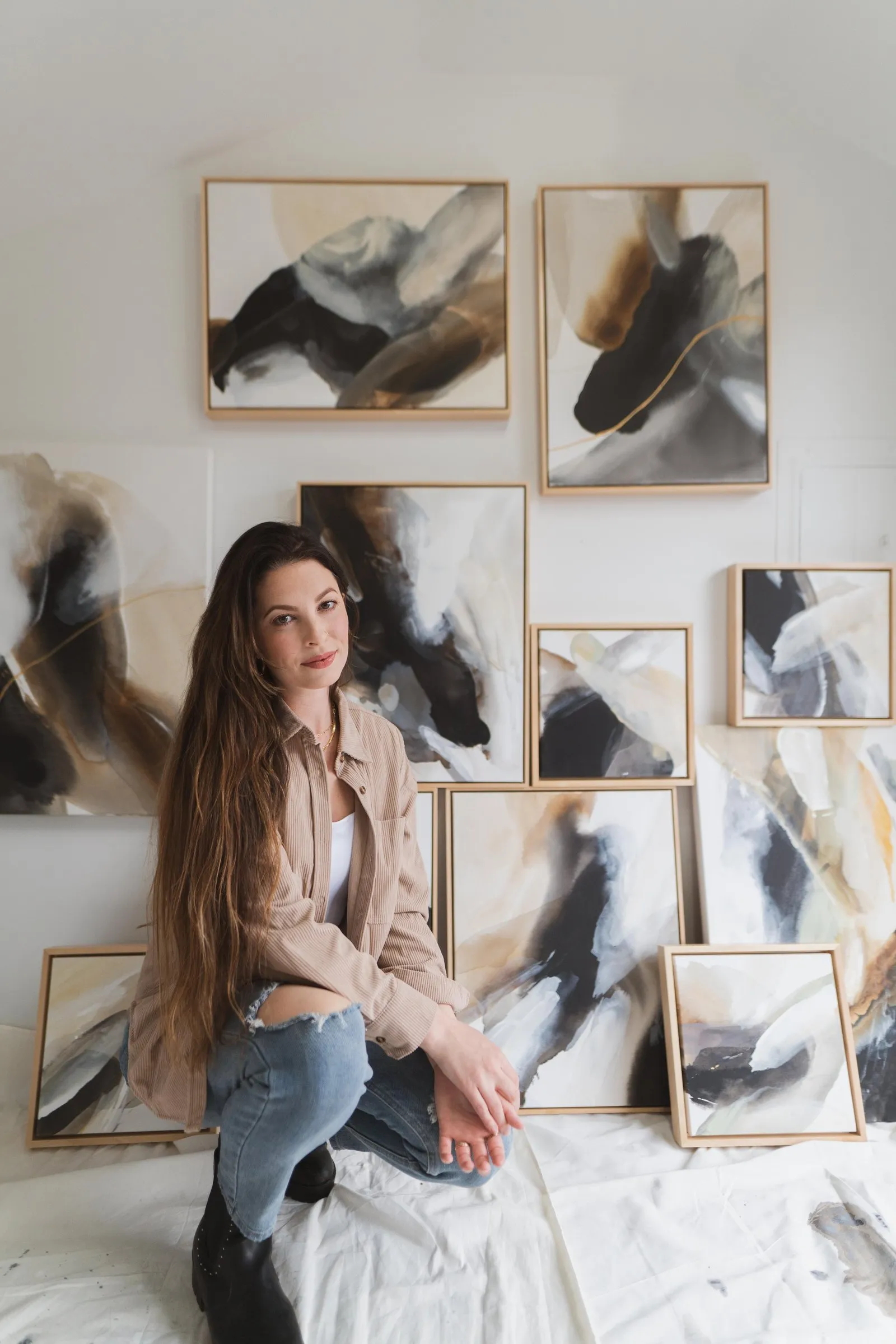 Rachel Reinert sitting in front of her A Change Within paintings