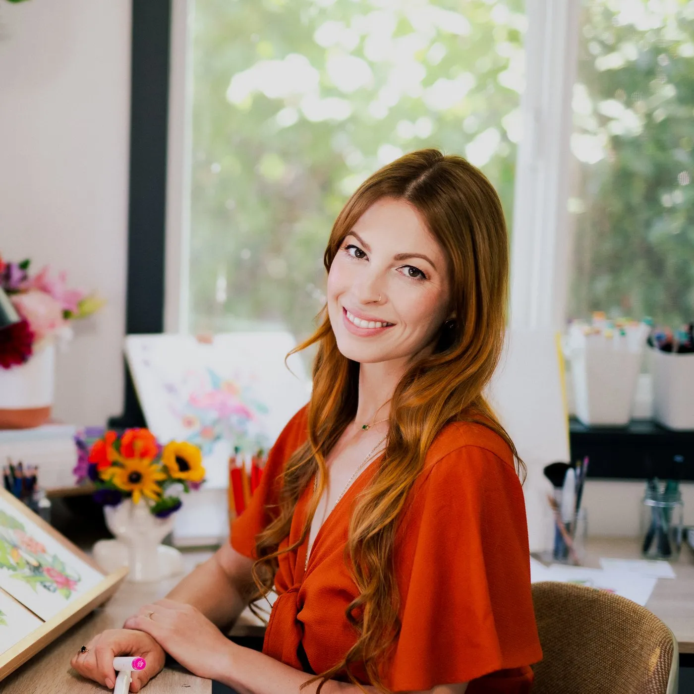 Rachel Reinert smiling at her studio desk
