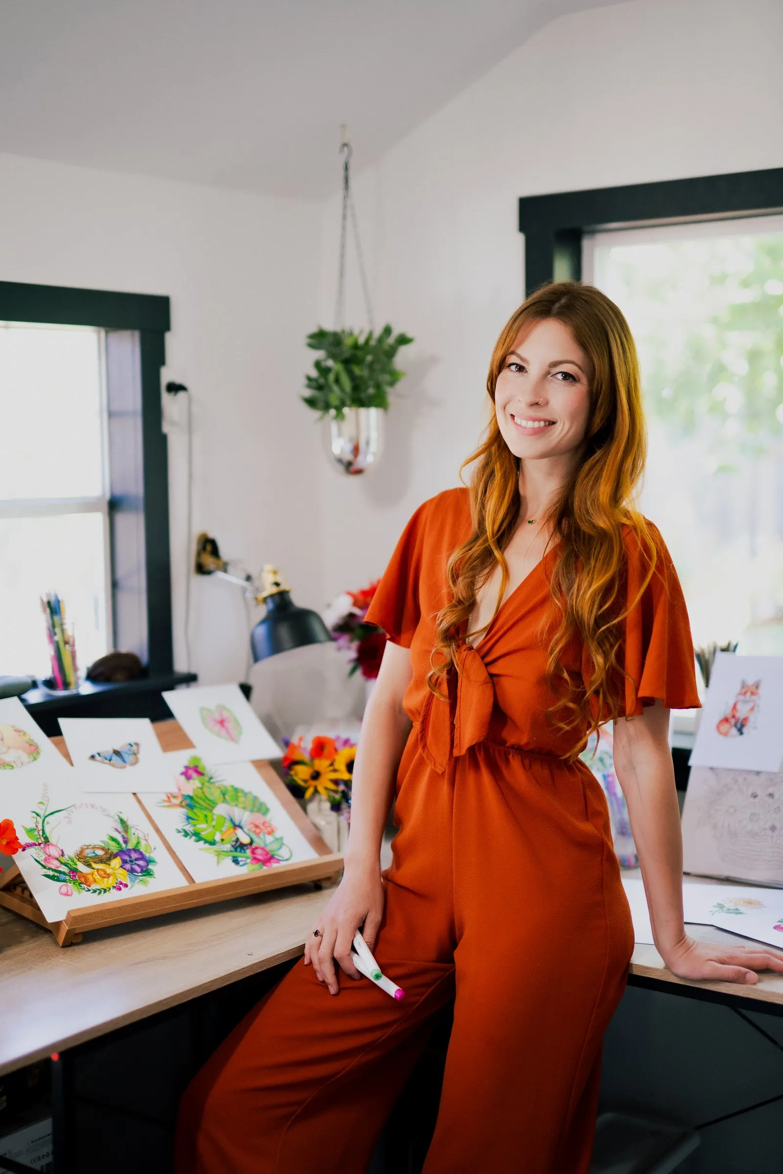 Rachel Reinert standing in her studio beside her colored pages