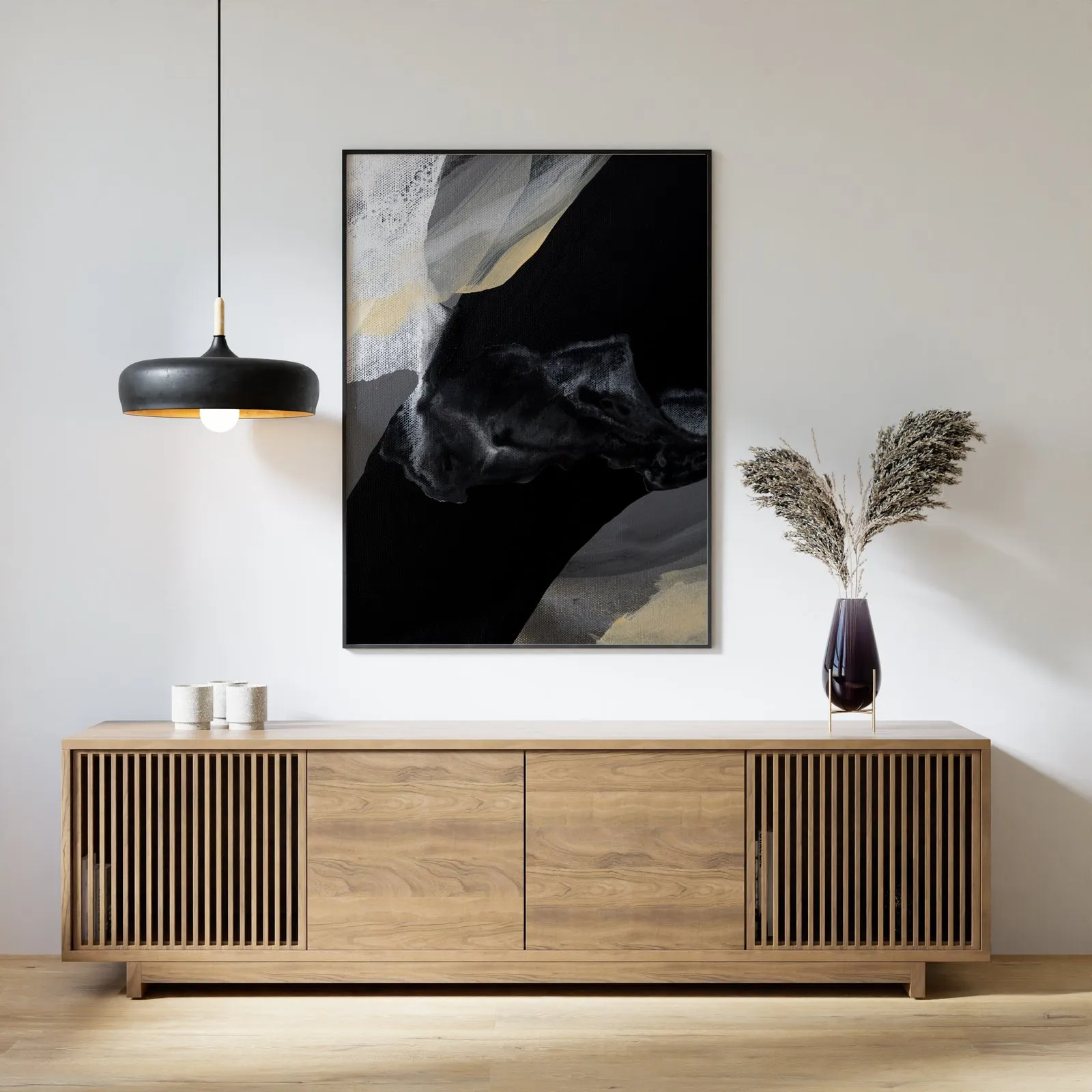 Black and beige abstract painting above a wooden console with a pendant lamp